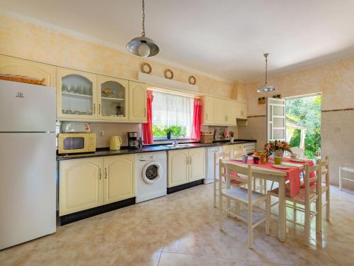 a kitchen with a table and a white refrigerator at Holiday Home Isaurinda by Interhome in Faro