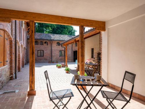 un patio con 2 sillas y una mesa en un patio en Apartment Il Tiglio by Interhome en Mondovì