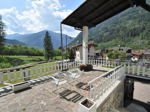 a patio with chairs and mountains in the background at Villa Villa Lucia by Interhome in Pellizzano