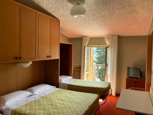 a hotel room with two beds and a window at Hotel Maria Nella in Bardineto