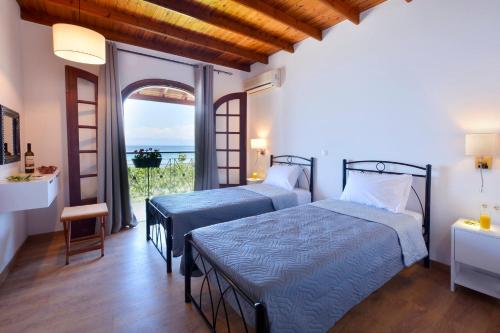 2 łóżka w pokoju z widokiem na ocean w obiekcie Alamanos House w mieście Mesongi