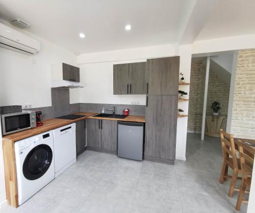 a kitchen with a washing machine and a dishwasher at Le temps d'une pause''' 