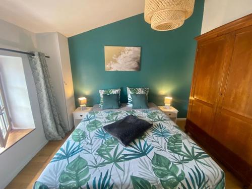 1 dormitorio con 1 cama con pared azul en La Mansarde De L Abbaye en Cluny