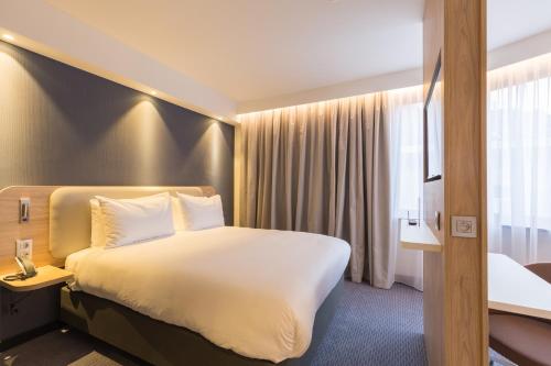 Habitación de hotel con cama grande y ventana en Holiday Inn Express Brussels-Grand-Place, an IHG Hotel en Bruselas