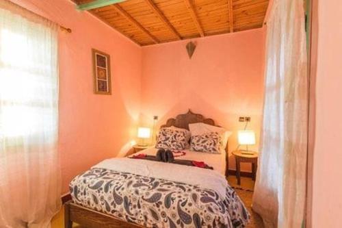 a bedroom with a bed in a room with pink walls at Room in Guest room - Room in villa Lair De La Mer in Sidi Kaouki