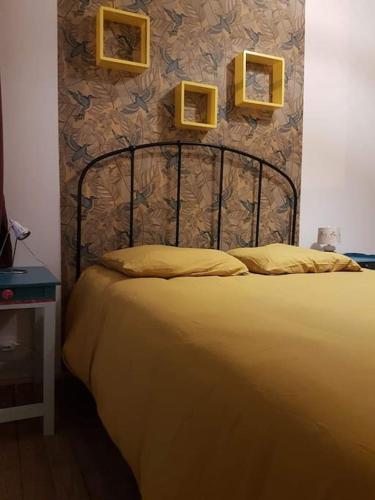 un lit dans une chambre avec deux tableaux au mur dans l'établissement Grande maison de ville entre terre et mer, à Malestroit