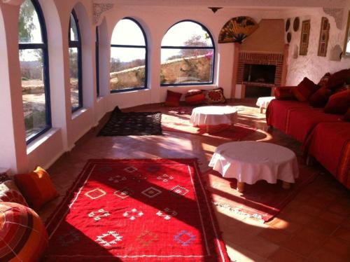 a living room with a red couch and windows at Room in villa Lair De La Mer in Sidi Kaouki