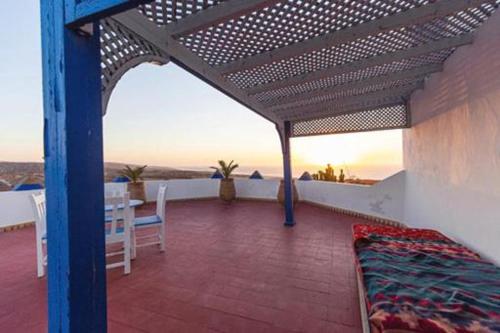 a patio with a table and a wooden roof at Room in villa Lair De La Mer in Sidi Kaouki