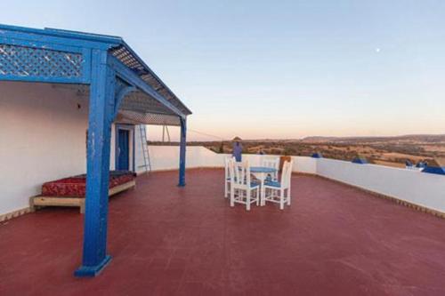 a balcony with a table and chairs on a roof at Room in villa Lair De La Mer in Sidi Kaouki