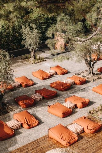 a bunch of orange pillows sitting on the ground at Cook's Club Ialysos Rhodes in Ialyssos