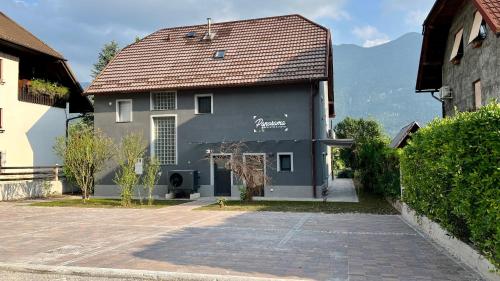 a gray building with a brown roof on a street at Panorama rooms in Bovec