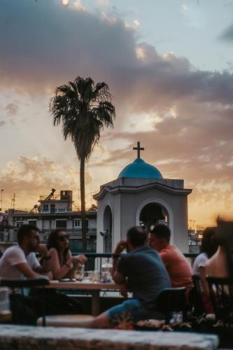 a group of people sitting at tables in front of a church at 193 Urban Hotel in Patra