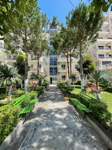 un parco con panchine e un edificio di Vila Beni a Shëngjin