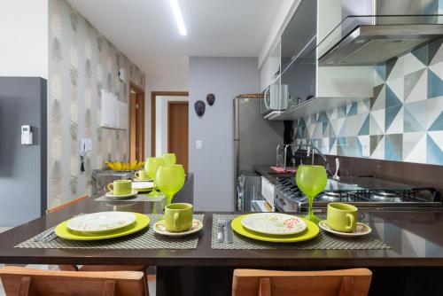 a kitchen with a table with yellow dishes on it at vemproCUPEPORTODEGALINHAS Casal ou Família no melhor apartamento de Porto de Galinhas in Porto De Galinhas