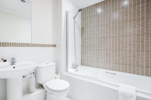 a white bathroom with a toilet and a sink at Roomspace Serviced Apartments - Royal Swan Quarter in Leatherhead