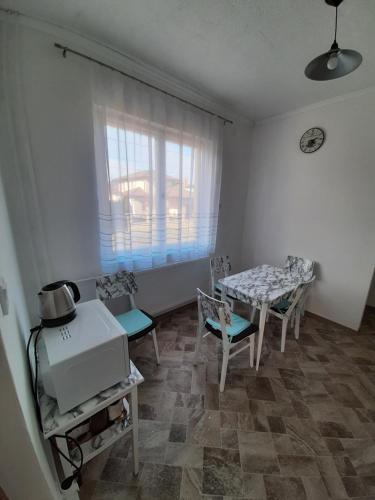 sala de estar con mesa, sillas y ventana en All-in-a good space, en Budapest