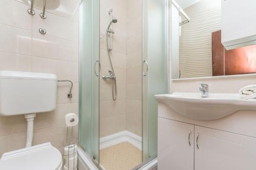 a bathroom with a toilet and a sink and a shower at Apartments Josip in Makarska