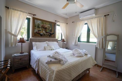 1 dormitorio con 1 cama con toallas en Villa Irene: Θέα πισίνα, Θέα θάλασσα, en Áyioi