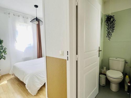 a bedroom with a white bed and a toilet at Cambo T1 Bis avec Terrasse pour 2, Parking - FR-1-495-105 in Cambo-les-Bains
