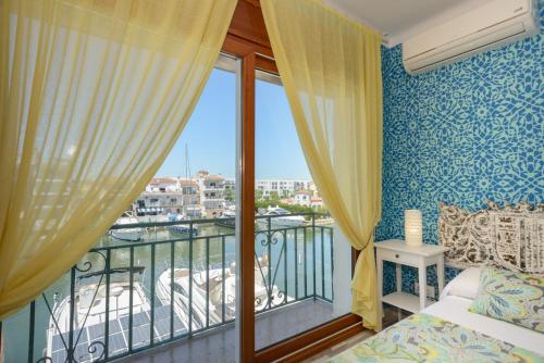 a bedroom with a balcony with a bed and a window at Port 27 in Empuriabrava