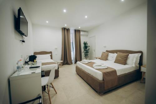 a bedroom with a bed and a desk and a television at Dimora Fantasia Charme B&B in Bari