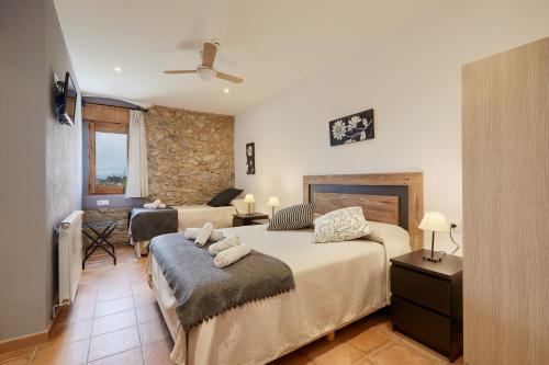 a bedroom with a bed and a living room at Mas Ribas Turismo Rural in Montiró