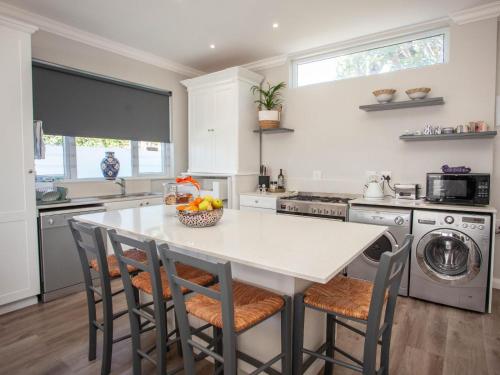 a kitchen with a table and chairs in a kitchen at No 4 Boutique Beach House in Summerstrand