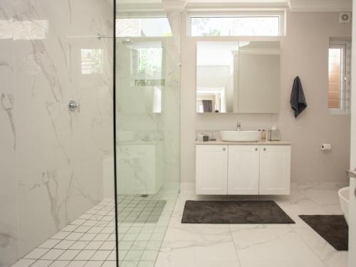 a bathroom with a shower and a sink at No 4 Boutique Beach House in Summerstrand