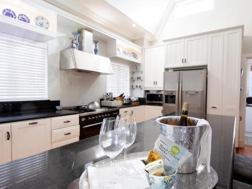 a kitchen with a counter with two glasses and a bottle of wine at No 4 Boutique Beach House in Summerstrand