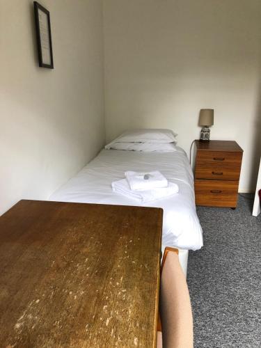 a bedroom with a bed and a wooden table at Sarum College in Salisbury