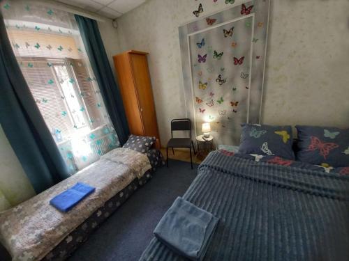 ein Schlafzimmer mit 2 Betten und ein Fenster mit Schmetterlingen an der Wand in der Unterkunft 1 комнатная квартира в центре Мукачева, улица Мира in Mukatschewo