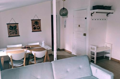 ein Wohnzimmer mit einem Sofa und einem Tisch mit Stühlen in der Unterkunft Ático encantador... in A Coruña