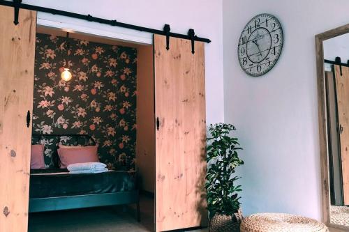 sypialnia z łóżkiem i zegarem na ścianie w obiekcie Ático encantador... w mieście A Coruña