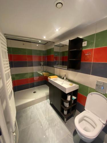 une salle de bain avec toilettes, lavabo et baignoire dans l'établissement La Mansarde De L Abbaye, à Cluny