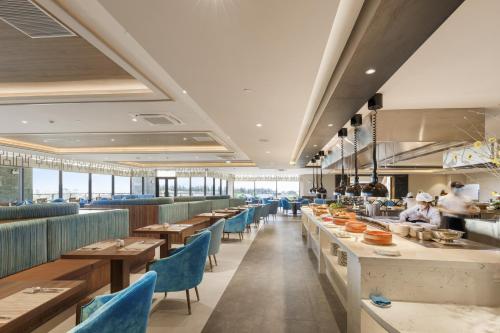 a restaurant with long tables and blue chairs at Da Nang - Mikazuki Japanese Resorts & Spa in Da Nang