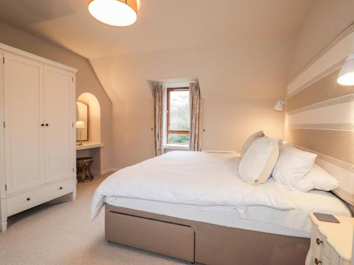 a bedroom with a large bed and a window at Smithy Cottage in Achnasheen