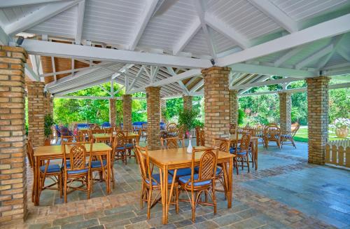 an outdoor patio with wooden tables and chairs at Chrismos Luxury Suites Apraos Corfu in Apraos