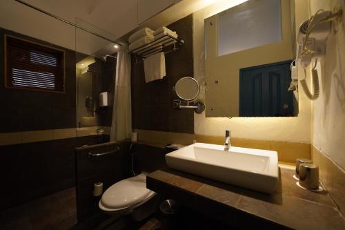 a bathroom with a sink and a toilet and a mirror at Zone Connect by The Park Calangute in Goa Velha