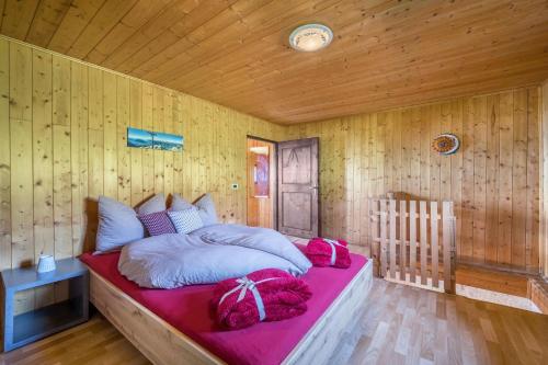 una camera da letto con letto in una camera in legno di Almhütte Jägerrast a Verano