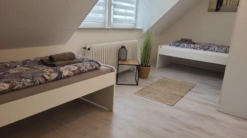 ein kleines Zimmer mit 2 Betten und einem Fenster in der Unterkunft Colin in Bremerhaven