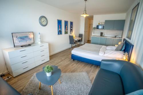 sypialnia z łóżkiem, kanapą i stołem w obiekcie Studio 34 "Leuchtfeuer" mit Meerblick w mieście Grömitz