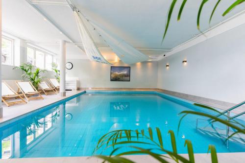 a swimming pool with blue water in a house at Studio 34 "Leuchtfeuer" mit Meerblick in Grömitz