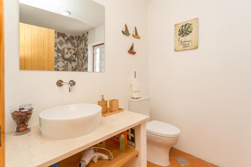 a bathroom with a sink and a toilet at Casa do Peladiço in Fataca