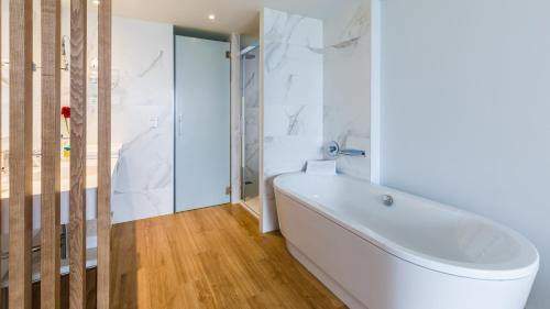 a white bathroom with a tub and a shower at Talayot - Adults Only in Cala Millor