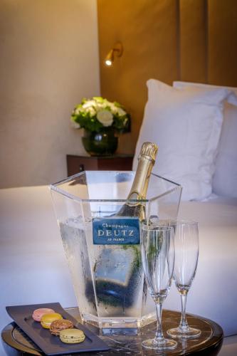 a bottle of champagne and two glasses on a table at Hôtel La Bourdonnais by Inwood Hotels in Paris