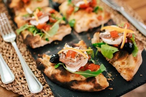 a plate with three slices of pizza on a table at Torre Don Virgilio Country Hotel in Cannizzara