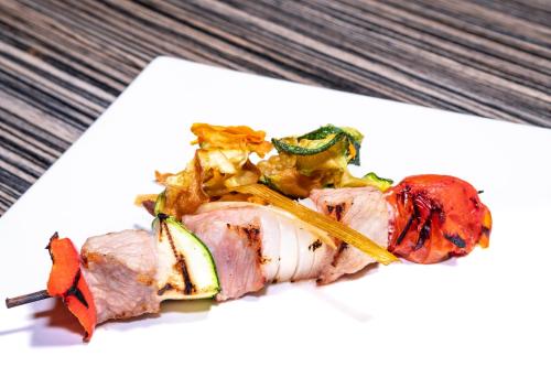 a piece of meat with vegetables on a white plate at Nuevo Torreluz in Almería