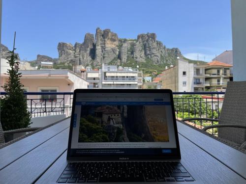 a laptop computer sitting on a table on a balcony at Meteora Casa Di Stella in Kalabaka