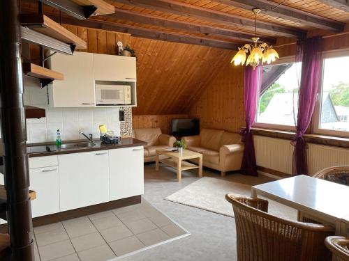 a kitchen with white cabinets and a living room at Westerwälder Hof Windhagen in Windhagen