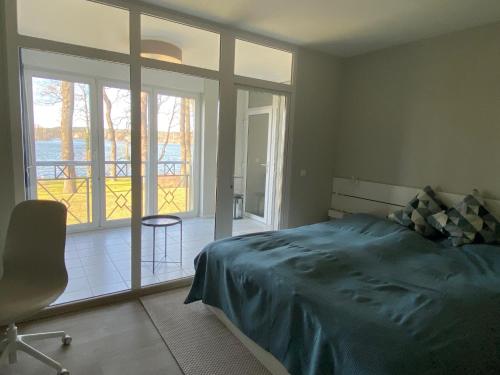 ein Schlafzimmer mit einem Bett und einem großen Fenster in der Unterkunft Apartment am See Bad Saarow in Bad Saarow